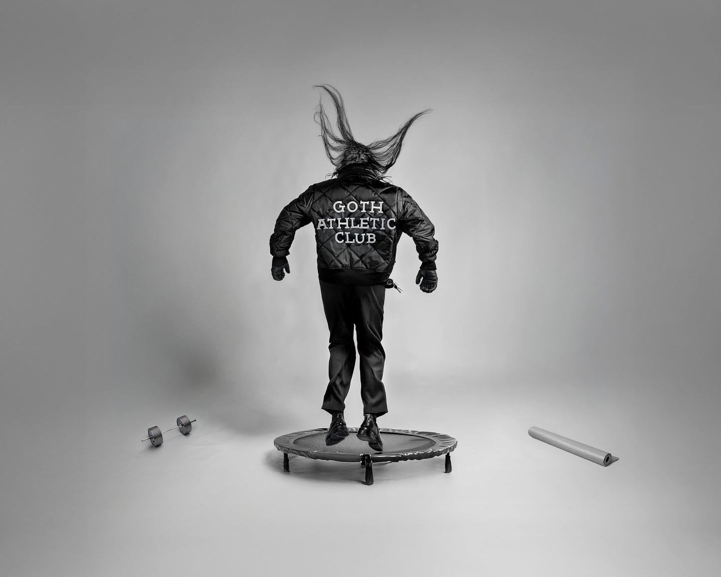 Gothic Athletic Club by Erin Naifeh - bold black and white photography about belonging with figure in Goth Athletic Club jacket jumping on trampoline