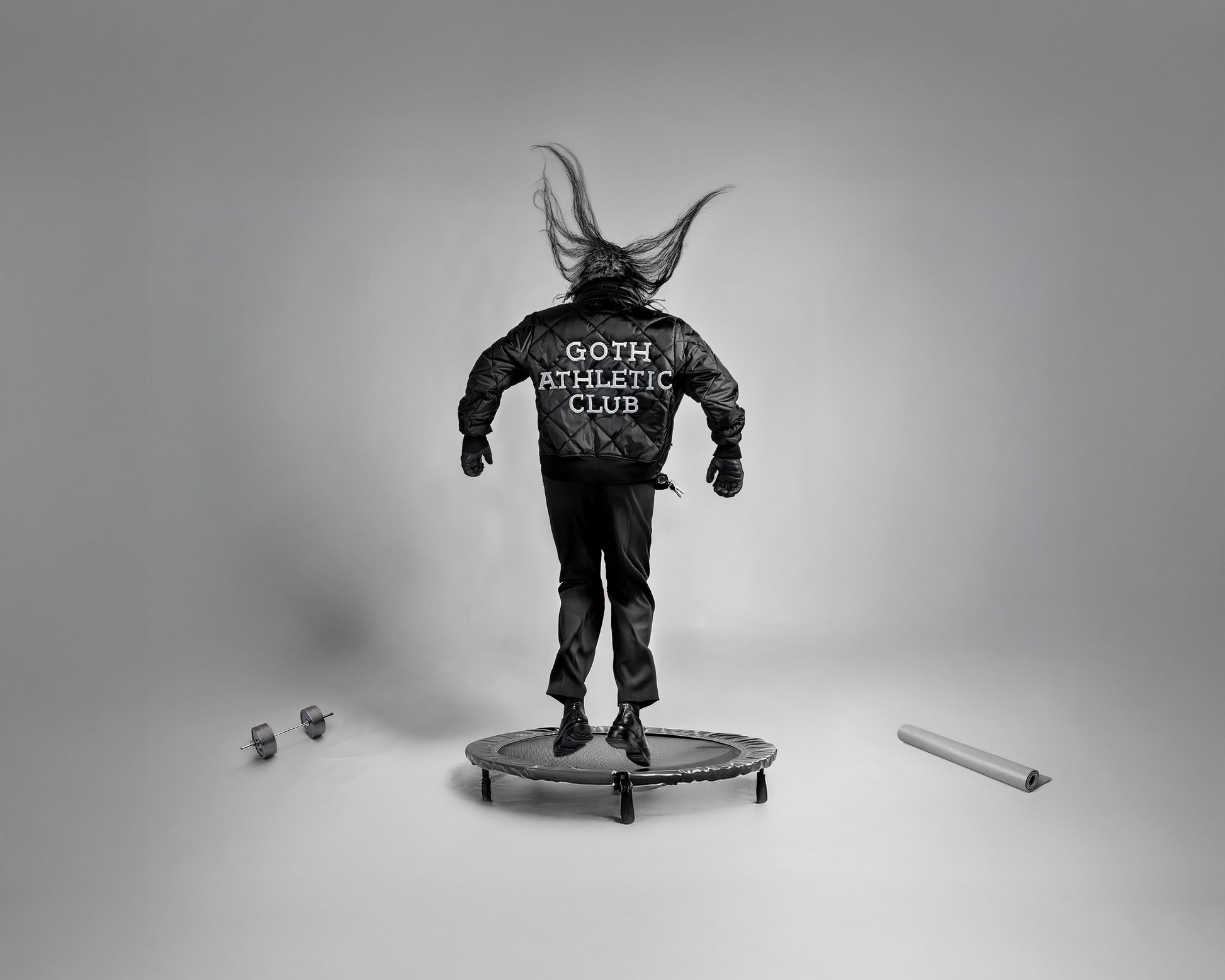 Gothic Athletic Club by Erin Naifeh - bold black and white photography about belonging with figure in Goth Athletic Club jacket jumping on trampoline